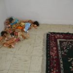 pile of barbie dolls in a corner of the room